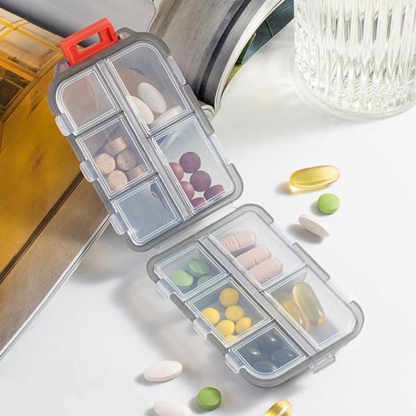Pill organizer with various pills on a light surface